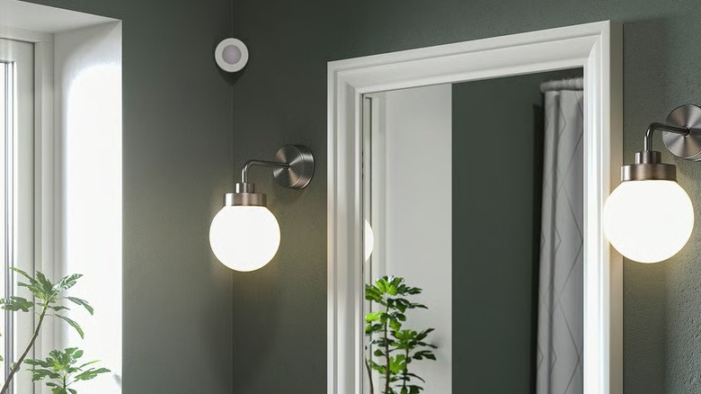 Ikea Myggspray Wireless Motion Sensor mounted on wall to control mirror lights