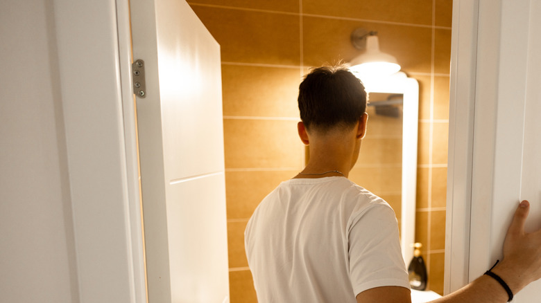 Man entering bathroom with lights on