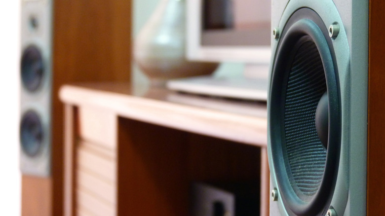 Wooden tower speakers with a TV in the background between them