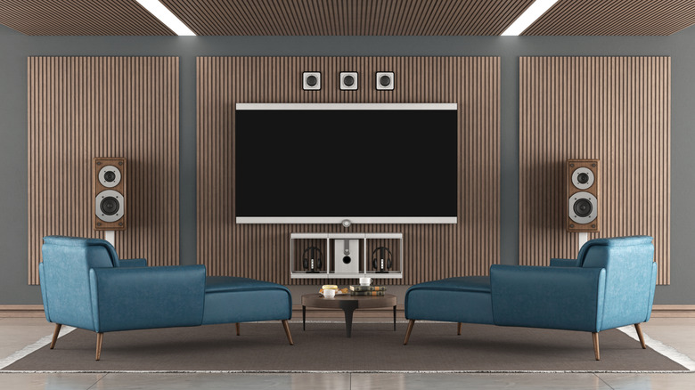 Wall-mounted flat screen tv with several external speakers around it