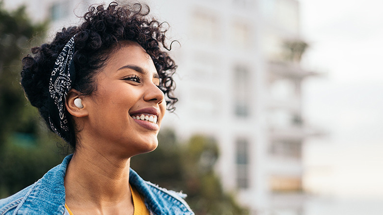 A woman wearing JBL Vibe Buds 2 earbuds.