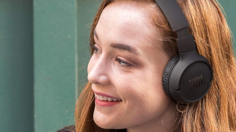 A woman wearing a pair of JBL Tune headphones.