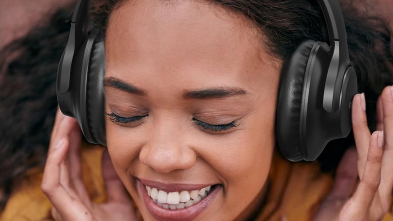 A woman wearing KVidio Over-Ear Bluetooth Headphones.