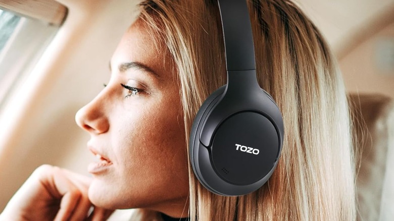 A woman wearing a pair of Tozo wireless headphones.