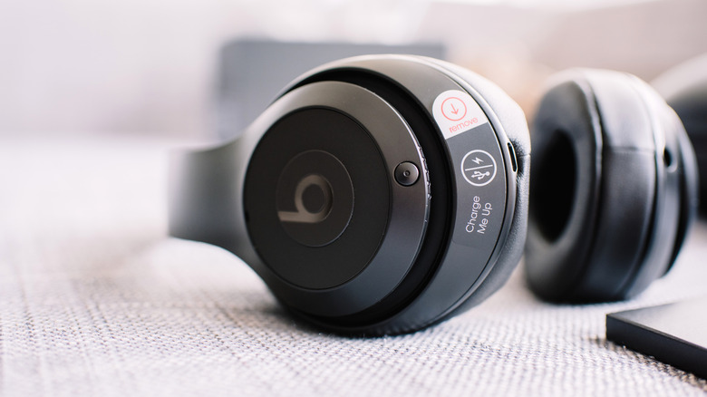 A pair of Beats headphones lying on a cloth. The headphones feature the Beats 