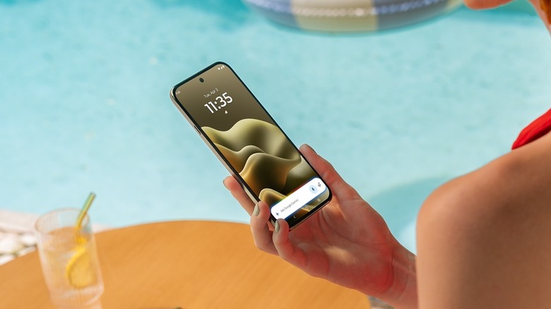 Close-up of a person holding the Motorola Edge (2026) near a pool