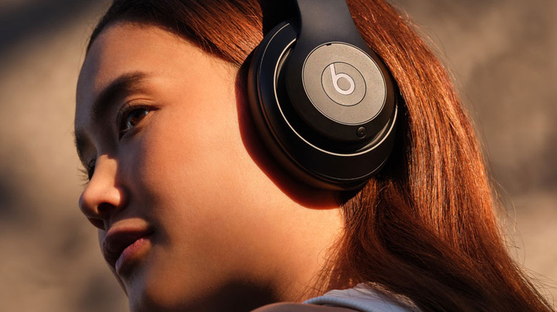 A woman wearing Beats Studio Pro looking off into the distance