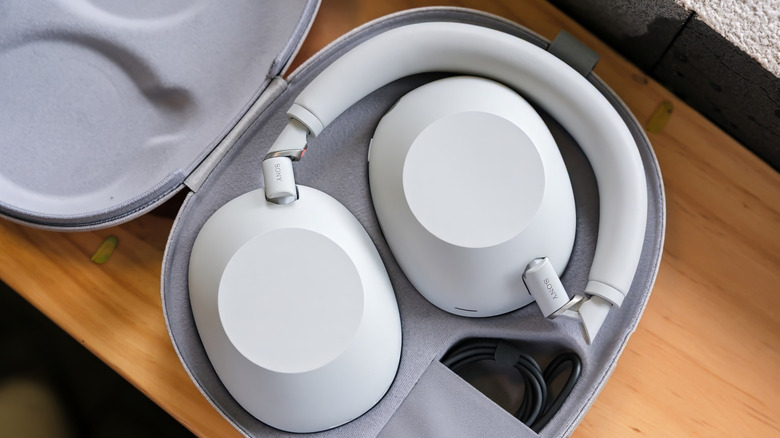 A pair of Sony Bluetooth headphones in their case sitting on a clean desk