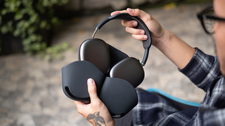 Someone pulling a pair of Apple AirPods Max out of the carrying case