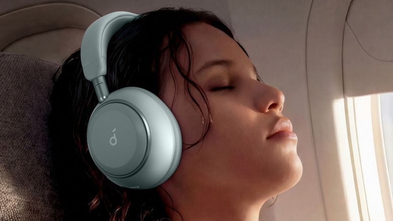 A person on a plane wearing the Soundcore Space 2 headphones with their eyes closed