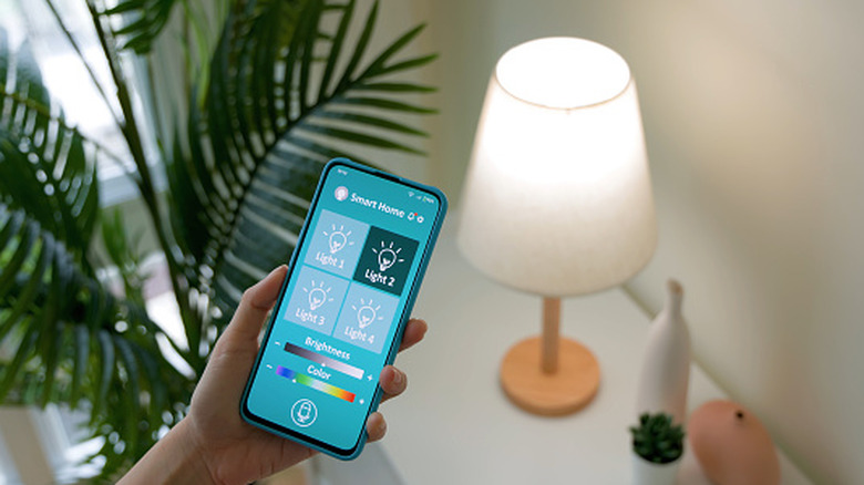 A person using a smartphone to control smart lighting.