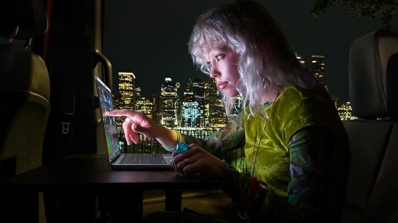 Woman uses a MacBook with touch late at night