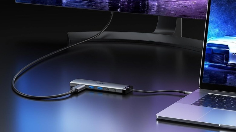 Acer 8-in-1 USB-C Hub connected to laptop and a monitor with RGB lighting in the background