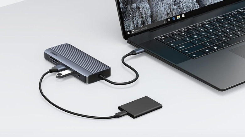 Anker A83C2 USB-C Hub connected to a laptop and an external SSD placed on a grey surface