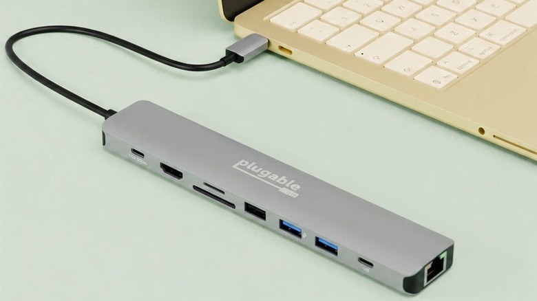 Plugable USBC-9IN1E 9-in-1 USB-C Hub connected to a MacBook placed on a light green surface