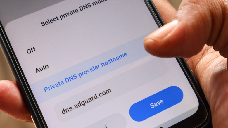 An iPhone with private DNS options on its display is pictured.