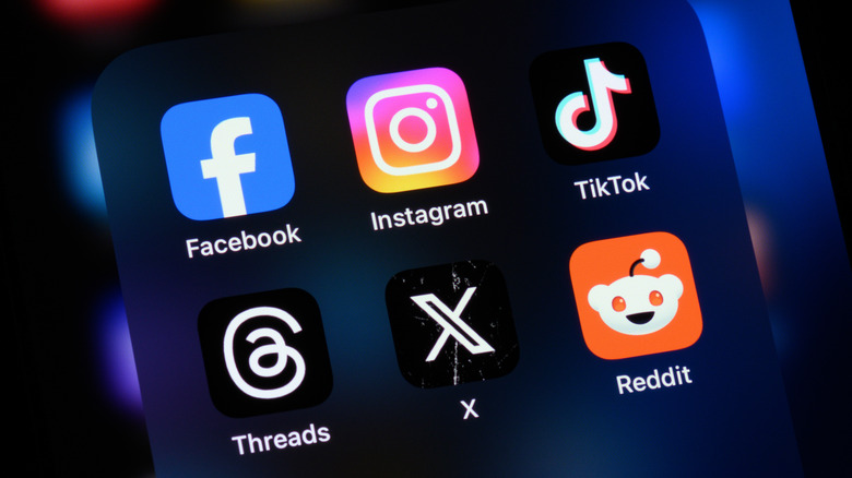 An iPhone with various app icons on the screen is pictured.