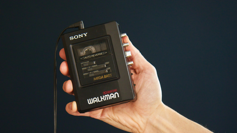 A person holding up a Sony Walkman tape player.