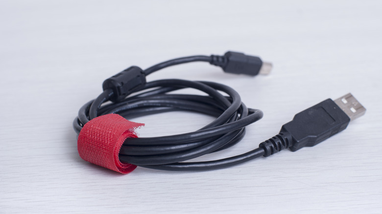 Coiled USB cable secured with a red strap.