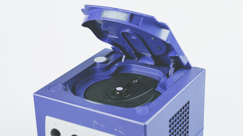 A Nintendo GameCube with its disc tray lid open.