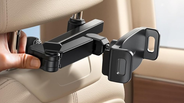 A black Lamicall Car Headrest Tablet Holder attached to the arms of a vehicle's headrest