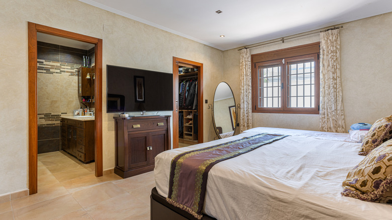 A TV in a bedroom across from the bed