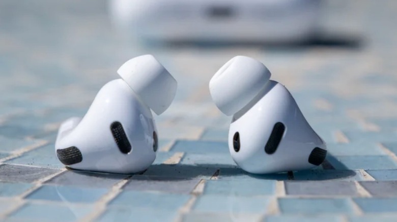 A pair of Apple AirPods Pro 3 earbuds one some blue tiles