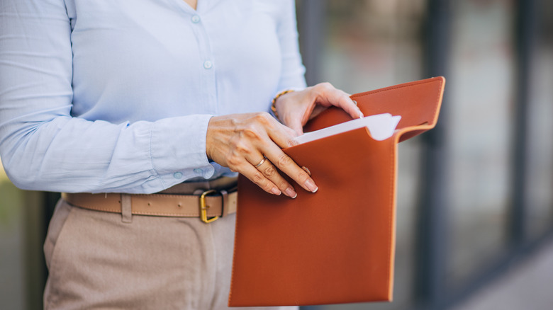 Person opening folder with important documents