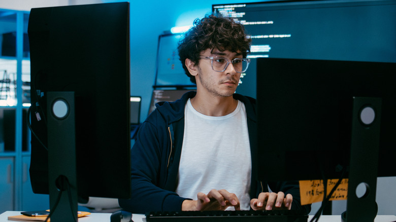 A software engineer working on two monitors.