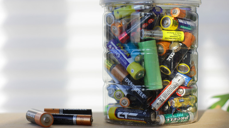 A jar of used batteries on a tabletop