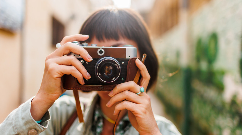 A woman taking a photo with a vintage camera