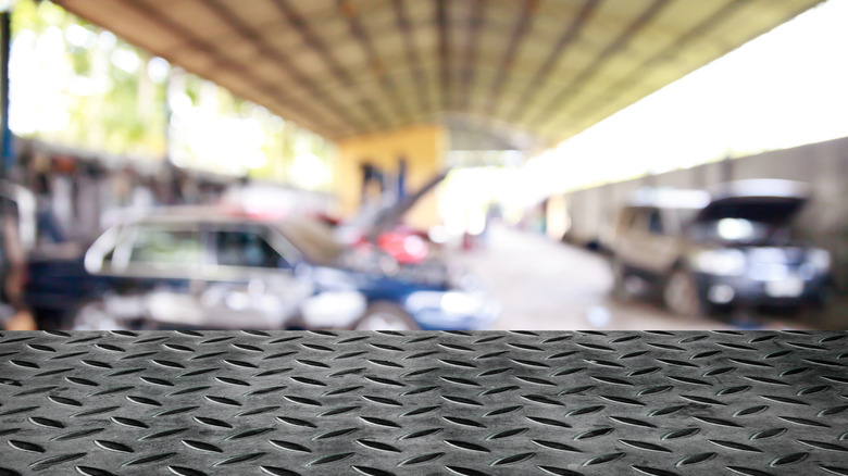 Metal surface visible in foreground with garage out of focus in background.