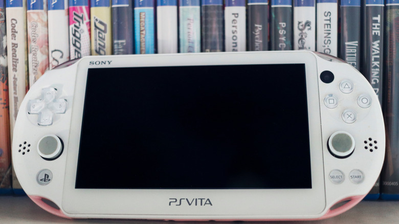 A PS Vita standing in front of physical game cases