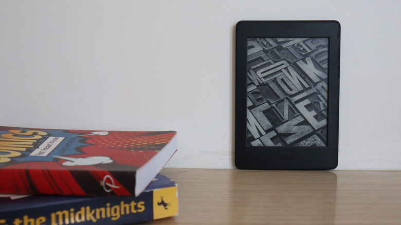 Kindle reader on a table with books