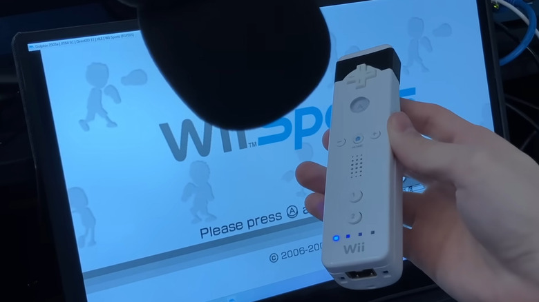 A modified Wii Remote with a microphone pointed at its speaker