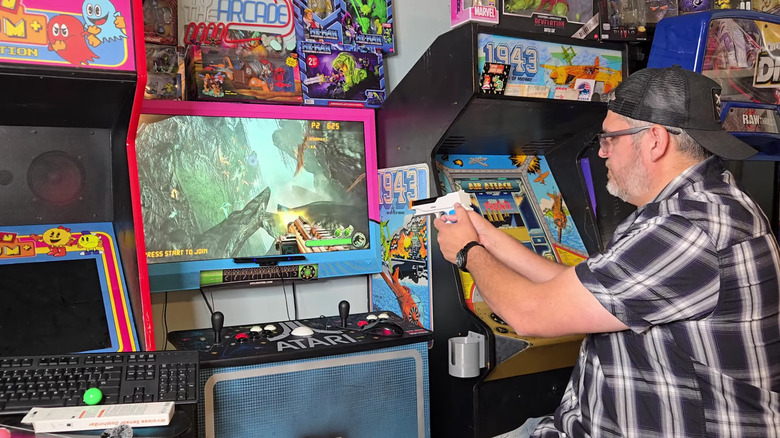 Wii Remote with gun attachment pointed at a monitor