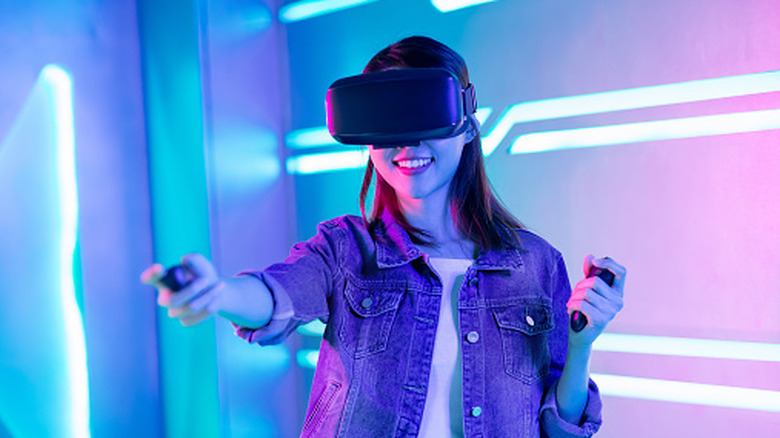 A woman wearing a VR headset with controllers in her hands