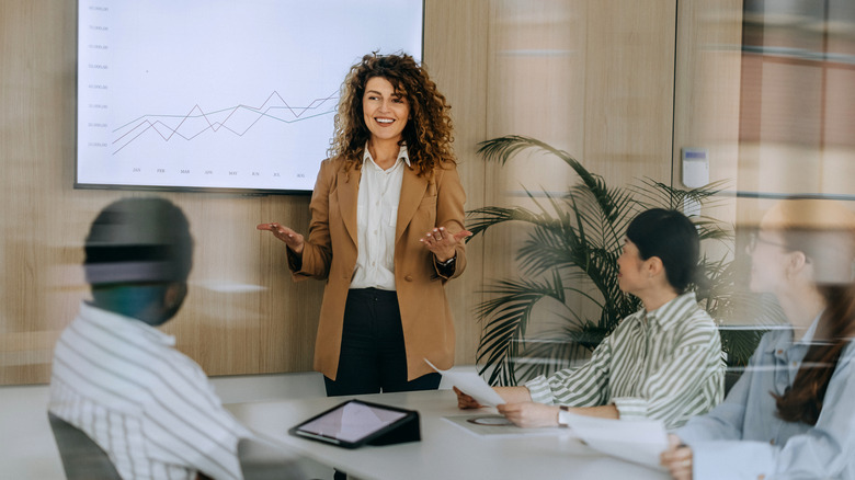 Woman giving a presentation to a group inside an office meeting room