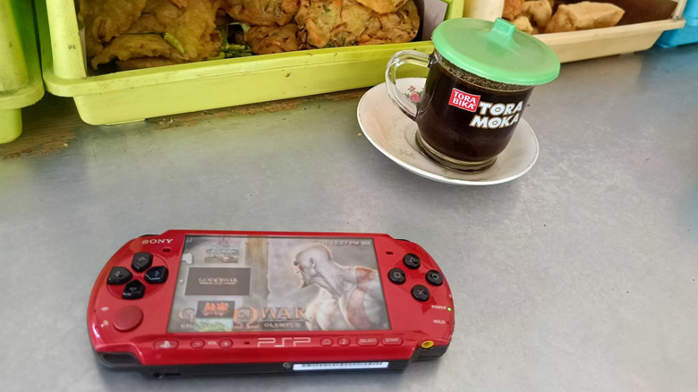 Red PSP sitting in table with screen on