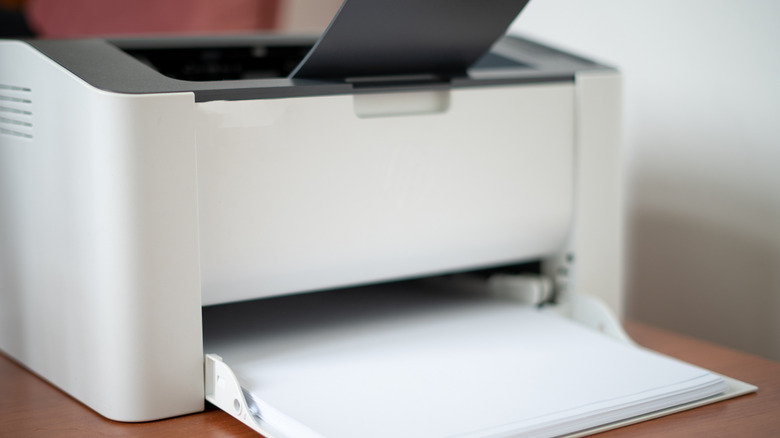 an old white inkjet printer placed on a brown table