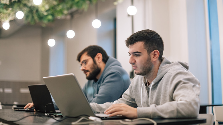 two people working on their laptop inside a library