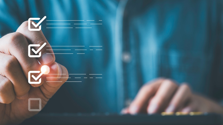 A person working on a computer checking to-do list checkboxes