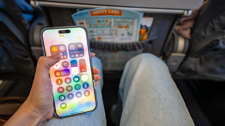 Person activating Airplane Mode on their phone while on airplane