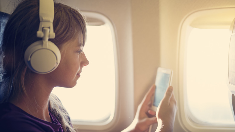 Person with headphones on a plane