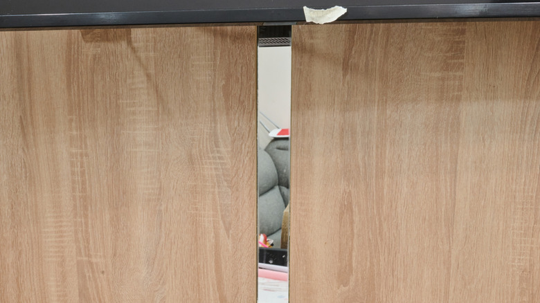 A wooden TV console with sliding doors.