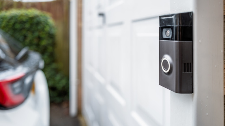 A Ring video doorbell mounted to the exterior of a garage door.
