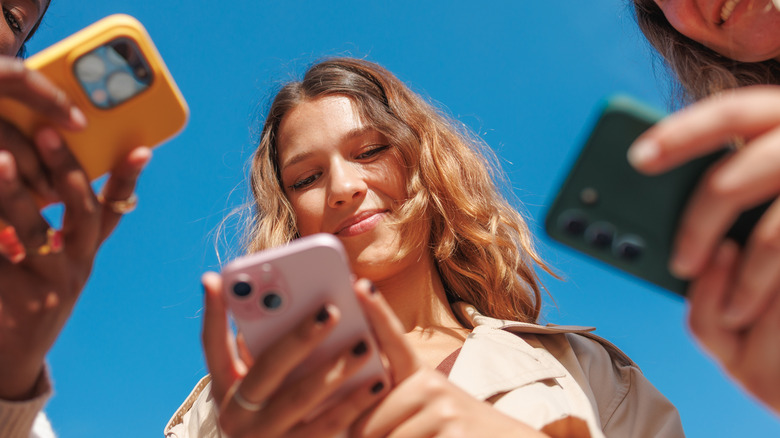 Teenagers holding their smartphones