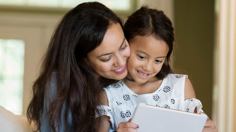 Daughter and mother enjoying content on a tablet