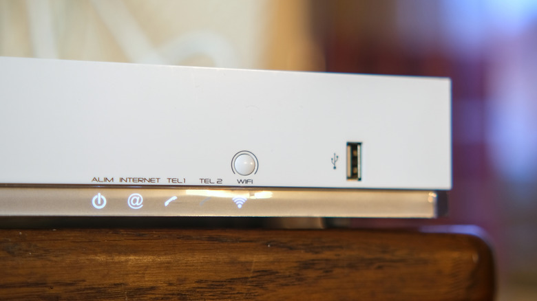 white router on a wooden table with indicators and USB port visible