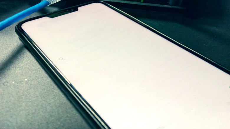 a router placed near a smartphone displaying a blank screen